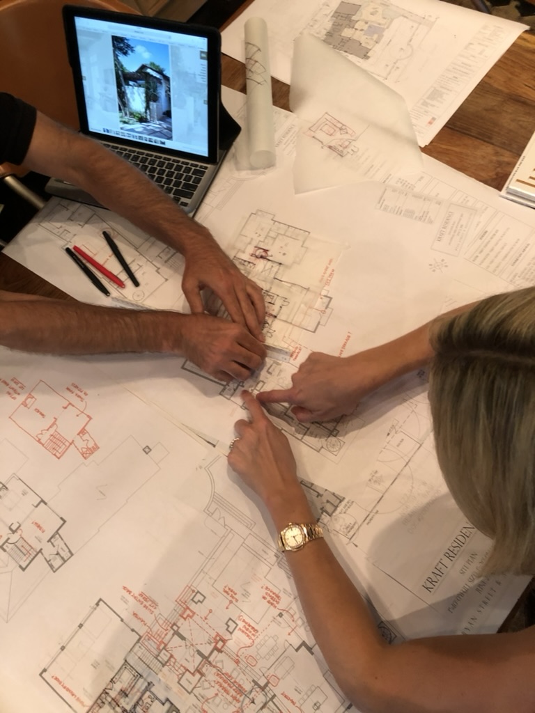 Hands marking up architectural plans for the Kraft Residence