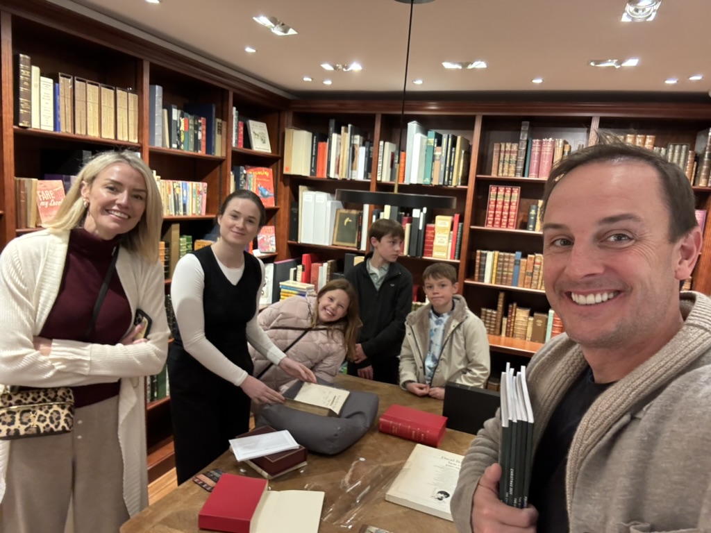 Allies gathered around a table in a wood-paneled antiquarian library